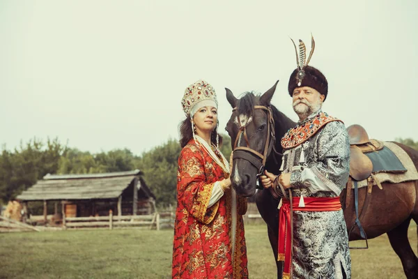 Rey y Reina vestidos con ropa medieval están de pie con el —  Fotos de Stock