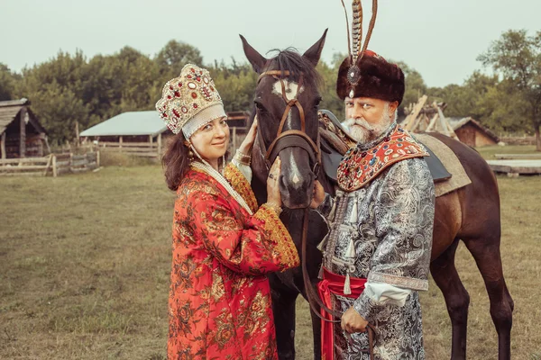 Koning en koningin gekleed in middeleeuwse kleding staan met de — Stockfoto