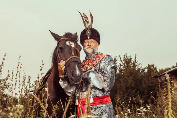 King klädda i medeltida dräkt strök sin häst på ru — Stockfoto