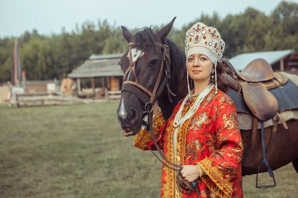 Ένα άλογο θα μεσαιωνική Αρχόντισσα στο κόκκινο φόρεμα και κοσμήματα — Φωτογραφία Αρχείου