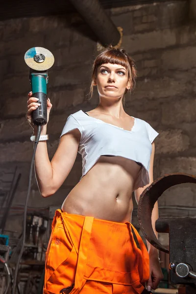 Mechanic woman in sexy uniform is working with the sander. — Stock Photo, Image