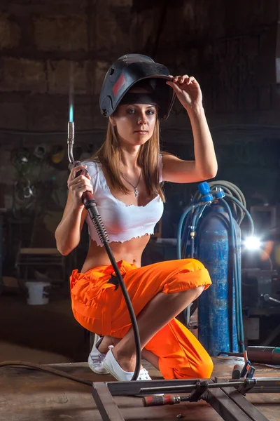 Blond sexy welder woman in the protective mask is looking at the — Stock Photo, Image