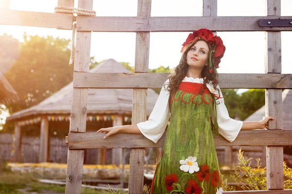 Młoda kobieta w rosyjski dress tradycyjne stoi w pobliżu drewniane — Zdjęcie stockowe