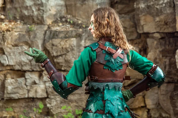 Elf woman in green leather armor pointing on something. — Stock Photo, Image