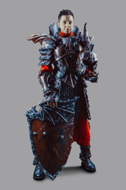 Elinde kılıç ve kalkanla ortaçağ kadın şövalyesinin portresi. Gri arkaplan üzerinde izole.