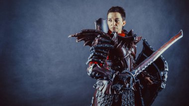 Mavi arka planda elinde kılıç ve kalkanla ortaçağ kadın şövalyesi portresi..