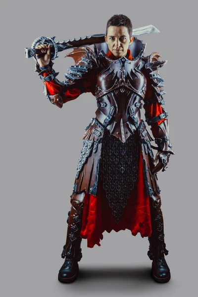 Elinde kılıçla ortaçağ kadın şövalyesinin portresi. Gri arkaplan üzerinde izole.