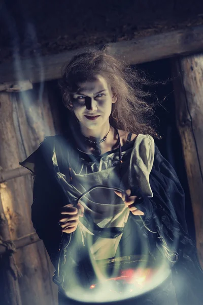 Pretty sorceress with the magic cauldron — Stock Photo, Image