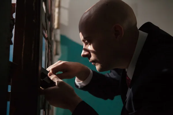 Bald hitman is going to open the door with the master keys. — Stock Photo, Image