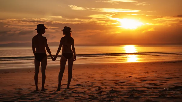 Bella coppia è in piedi sullo sfondo tramonto tropicale — Foto Stock