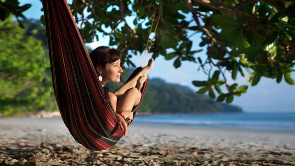 Hübsche Frau liegt auf der Hängematte am tropischen Ozean zurück — Stockfoto