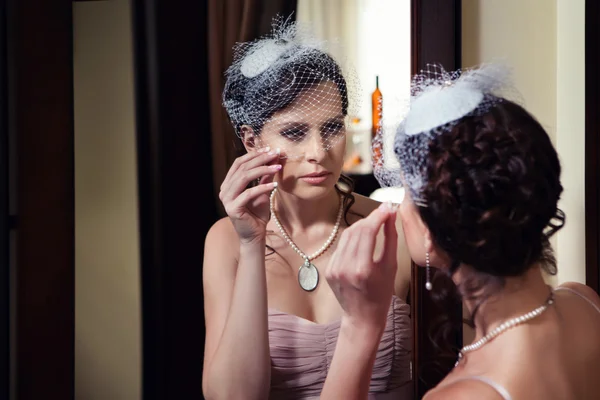 Schöne Frau mit Schleier blickt in den Spiegel. — Stockfoto