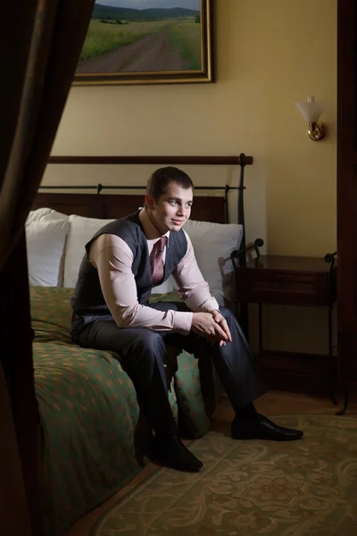 Smart gentleman is sitting on the bed and thinking. — Stock Photo, Image