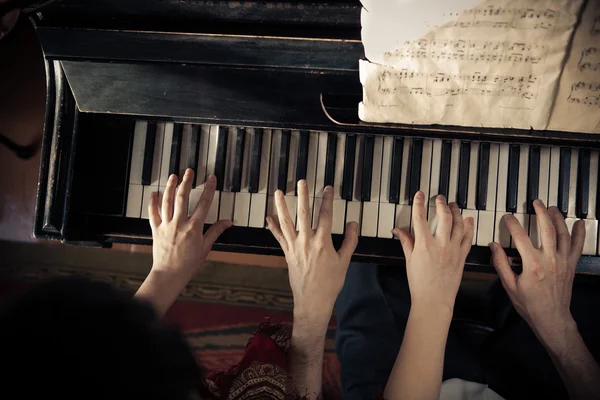 Uomo e donna suonano il pianoforte insieme — Foto Stock
