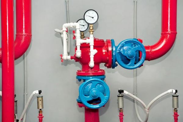 Red pipeline with manometers and blue gauges. Royalty Free Stock Photos