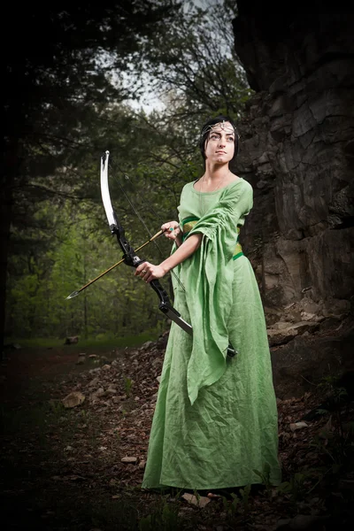 Elf vrouw met de magische boog op het bos achtergrond. — Stockfoto