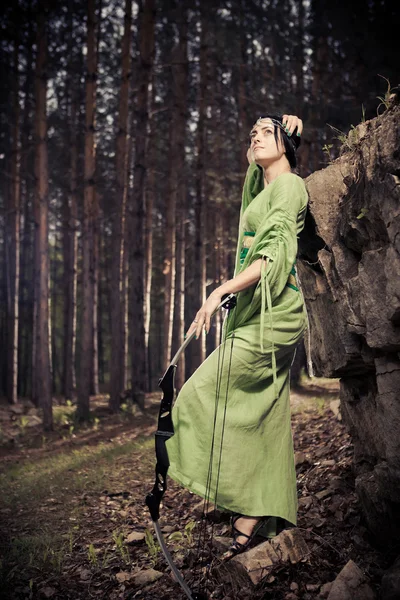 Mujer elfa con el arco mágico en el fondo del bosque . — Foto de Stock
