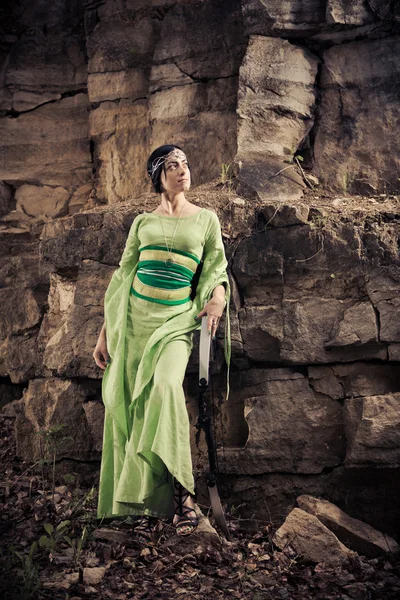 Mujer elfa con el arco mágico en el fondo de las rocas . — Foto de Stock