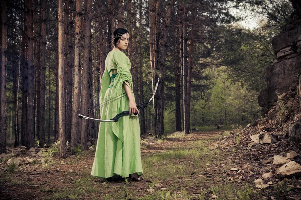 Mujer elfa con el arco mágico en el fondo del bosque . — Foto de Stock