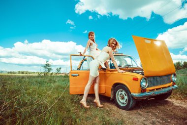 Araçları ile güzel kadınların kırsal yolda bir araba tamiri