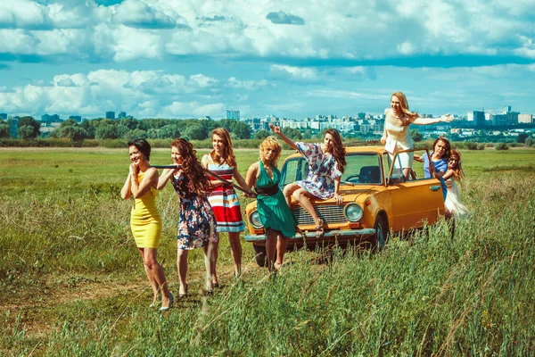 Groupe de femmes tire une voiture avec le câble de remorquage . — Photo