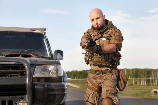 Aiming soldier in american uniform. Military SUV on the back — Stock Photo, Image