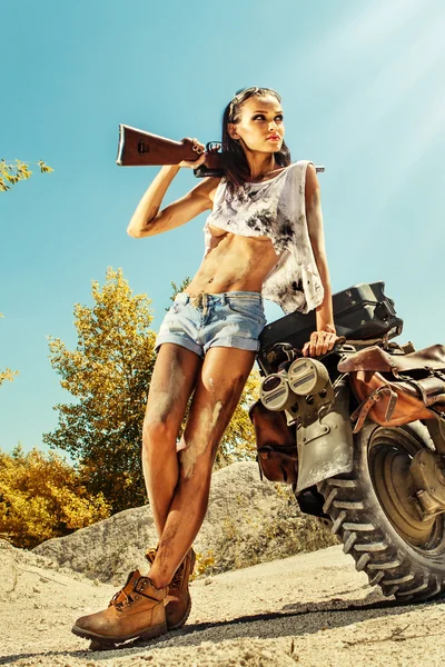 Sexy biker woman on the desert background. — Stock Photo, Image