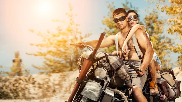 Sexy couple of bikers with guns on the summer background. — Stock Photo, Image