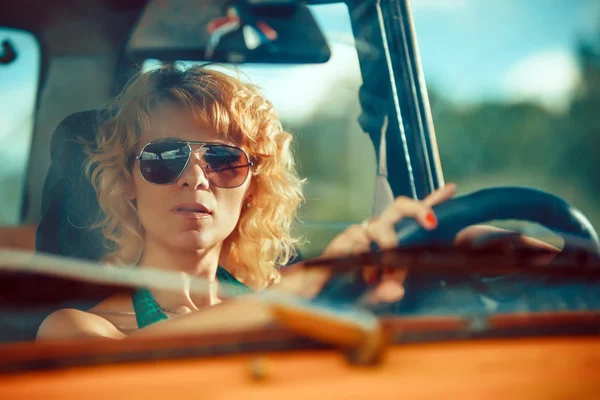 Woman is driving an old yellow car. Rural background. — Stock Photo, Image