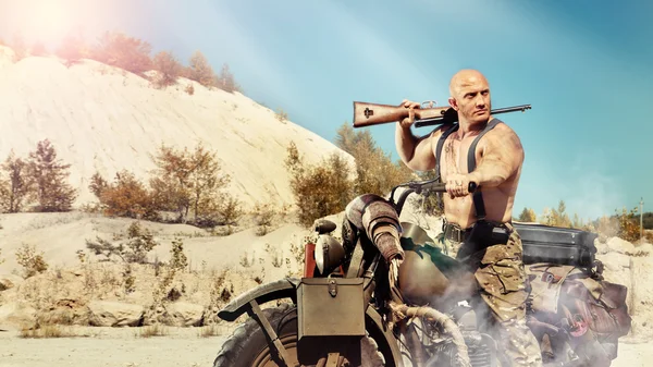 Muscular bald biker with the rifle — Stock Photo, Image
