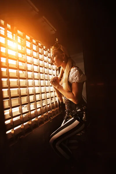 Jeune femme blonde regarde par la fenêtre de la cage — Photo