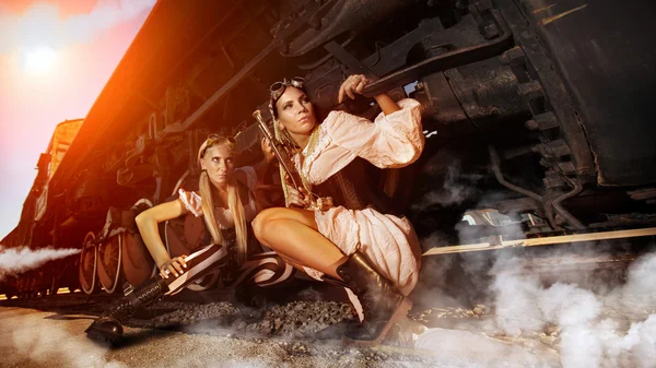 Two sexy woman in the steam-punk clothes are hiding beneath the — Stock Photo, Image