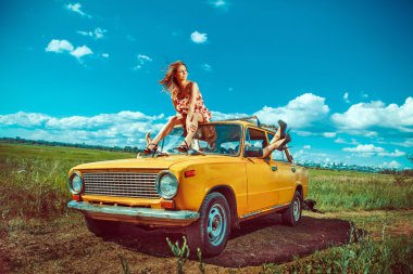 Group of beautiful women in the old yellow car clipart