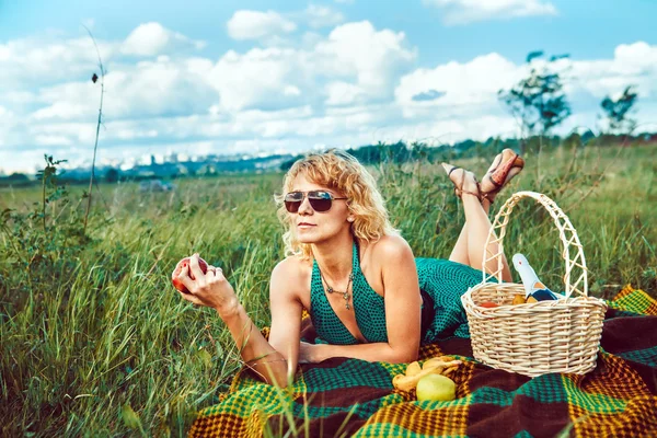 Sexy blond woman with the apple on the picnic. — Stock Photo, Image