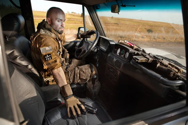 Skallig soldat i uniform driver militärfordon. — Stockfoto