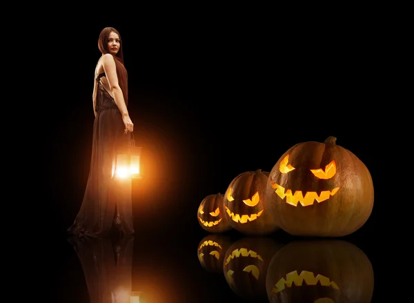 Büyülü fener ile güzel cadı. Halloween pumpkins üzerinde th — Stok fotoğraf