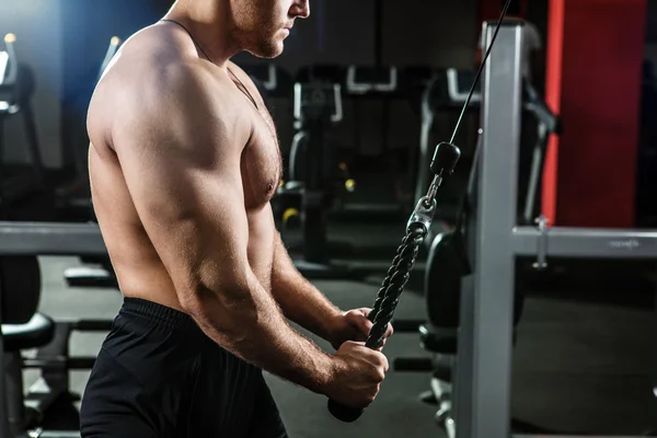 Uomo potente con corporatura muscolare si allena in palestra — Foto Stock