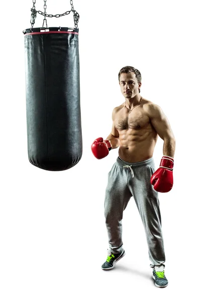 М'язистий боксер біля боксерської сумки. Ізольовані на білому тлі — стокове фото