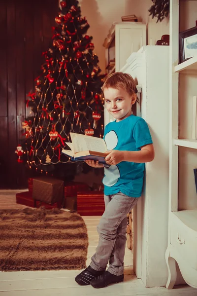 Милый блондин читает книгу сказок на Рождество. — стоковое фото