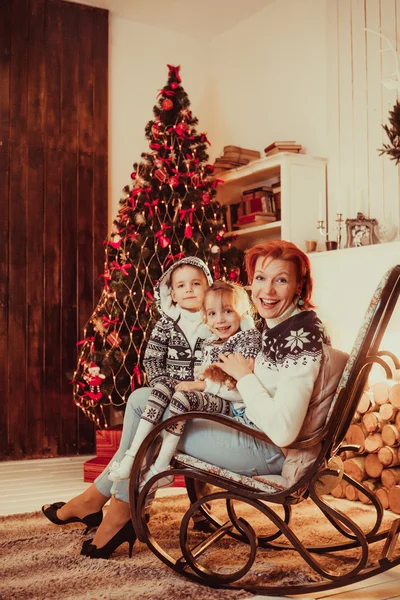 Смеющаяся мать с сыном и пончиком сидят на стуле — стоковое фото