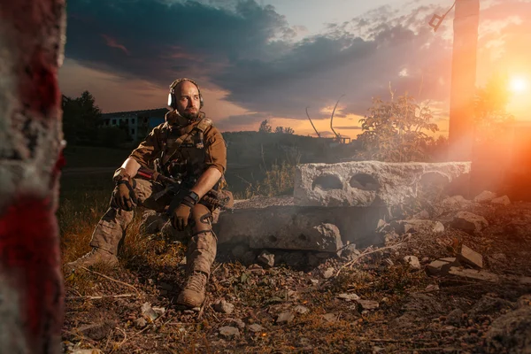 American soldier with the M4 rifle is having a rest. Sunset on t — Stock Photo, Image