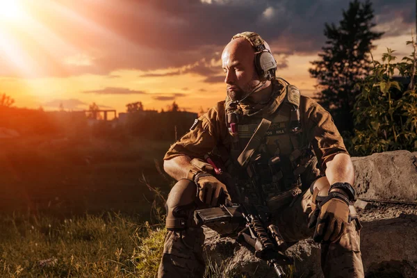 Soldado americano con el rifle M4 está descansando. Puesta de sol en t —  Fotos de Stock