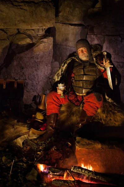 Medieval King in armor with the sword in one hand and wineglass — Stock Photo, Image