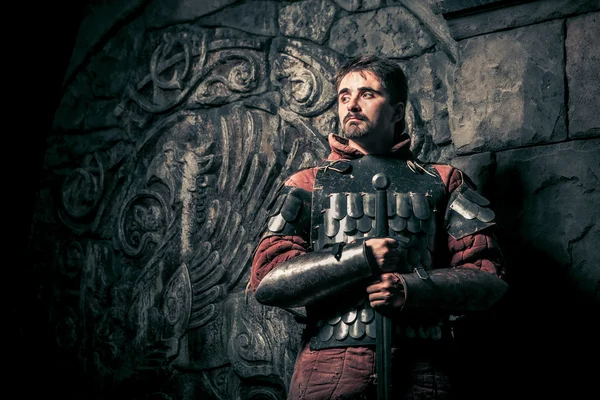 Средневековый рыцарь с мечом на фоне древнего замка — стоковое фото