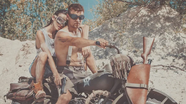 Sexy pareja de motociclistas con armas en el fondo de verano . —  Fotos de Stock