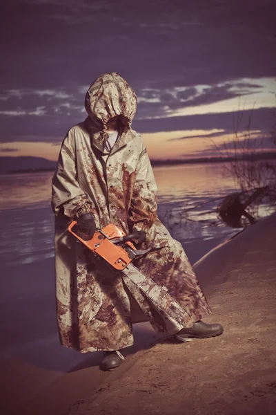 Maniac with the chainsaw on the sunset background. — Stock Photo, Image