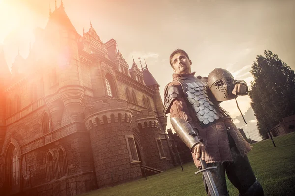 Medieval knight with the sword on the ancient castle background — Stock Photo, Image