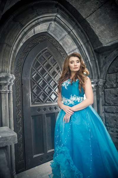 Princess in blue dress is going to open the castle door. — Stock Photo, Image