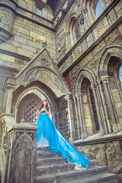 Princess in blue dress is going to open the castle door. — Stock Photo, Image