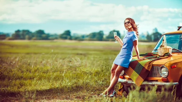 Mulher bonita no piquenique está bebendo vinho perto de um carro . — Fotografia de Stock